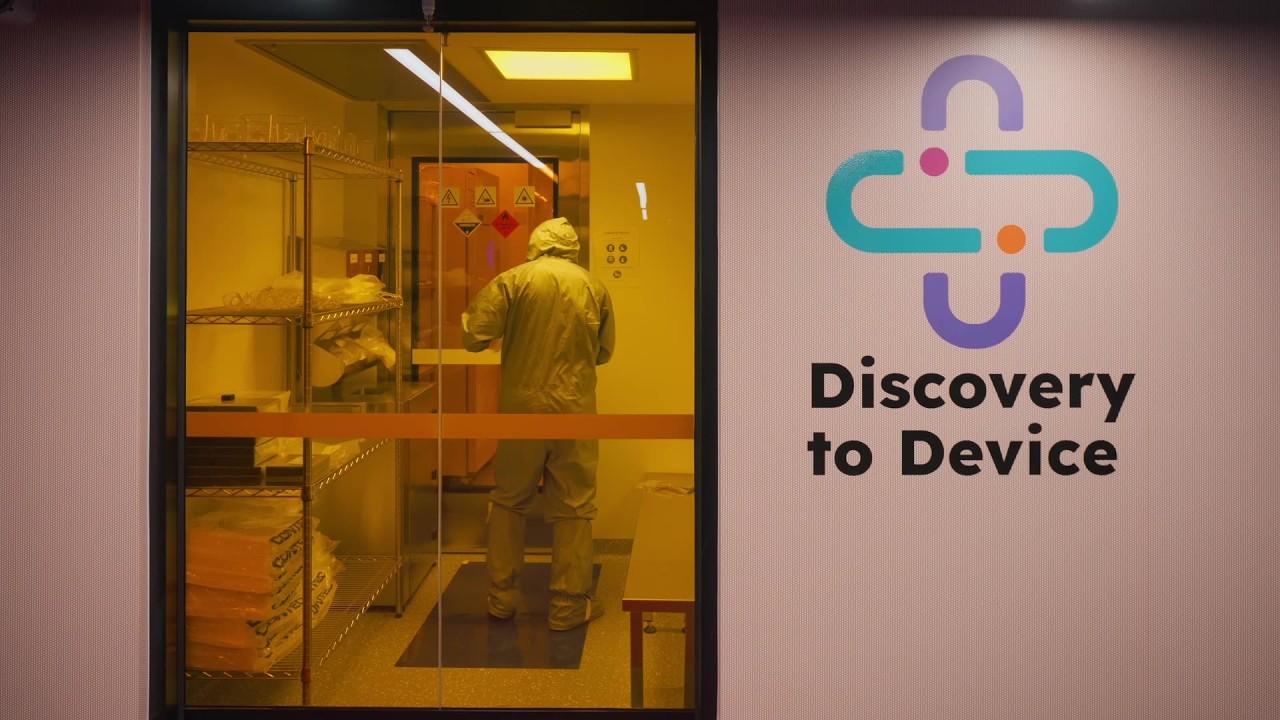 A technician in protective clothing working in an Australian research cleanroom